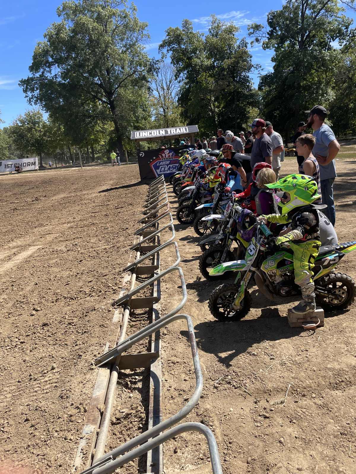 Sawyer on his green #75 bike on the starting line at Lincoln Trail with a full gate of riders